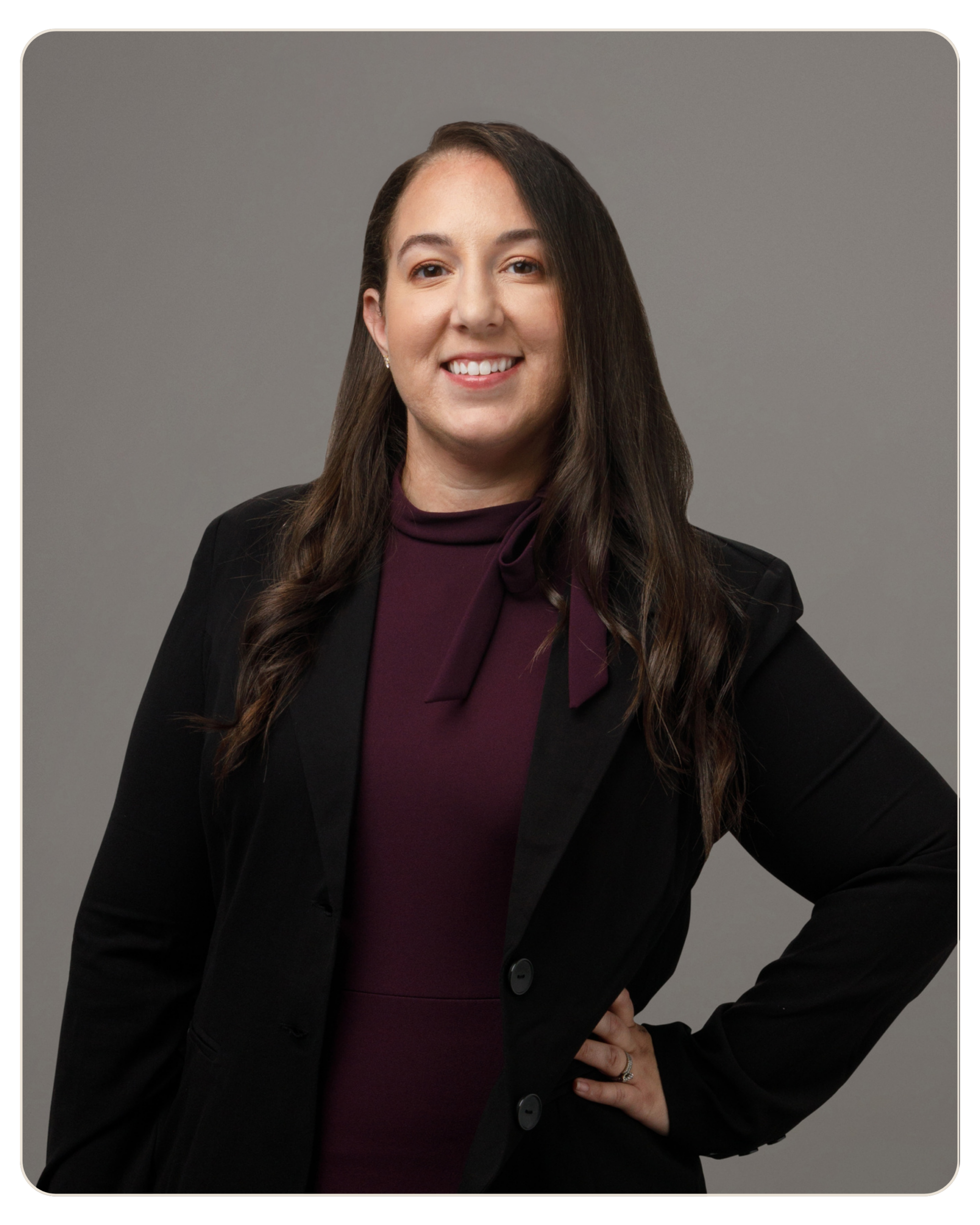 Flyland Crystal Donato Professional woman smiling in a black blazer with a burgundy blouse, neutral background (headshot).